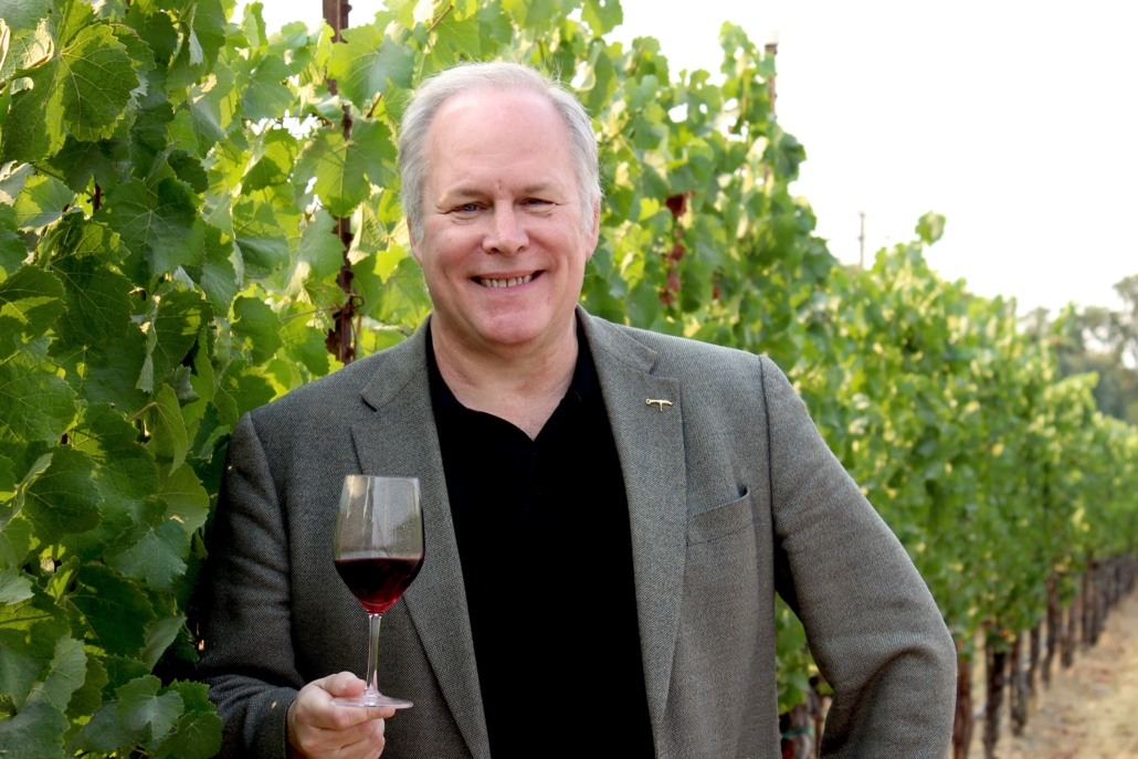 Michael Haney holding a wine glass in a vineyard
