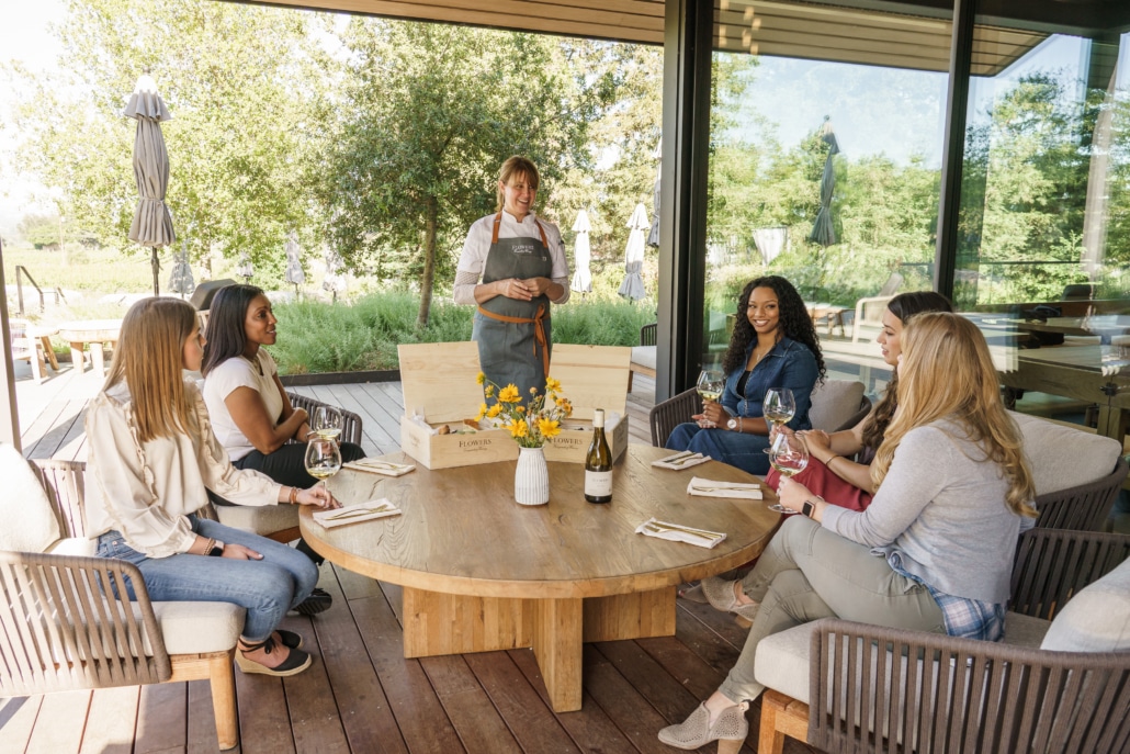 Women at a round table being led into a wine tasting