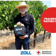 Ron Rubin holding an AED in a vineyard