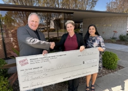 Sonoma County Vintners Foundation Executive Director Michael Haney presents a $50,000 donation to Cynthia King, Chief Executive Officer of of Community Action Partnership of Sonoma County and Kathy Gonzales-Kane, Chief Program Officer of Community Action Partnership of Sonoma County.  