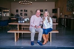 Dan Kosta and his wife sitting on a bench in the Convene tasting room